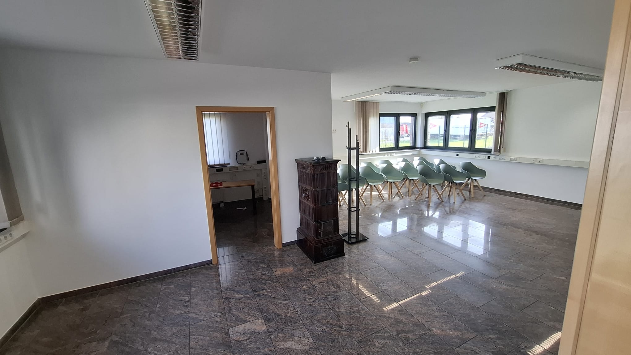 Tagungsraum mit Kaminofen und Küchenblick